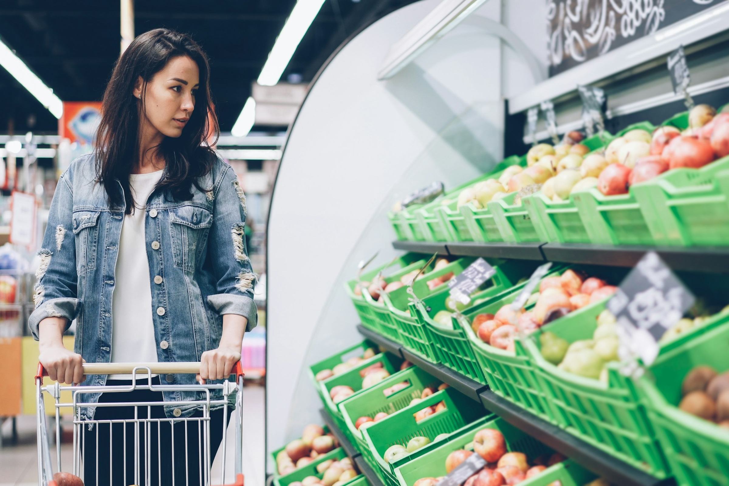 Une personne fait ses courses au marché, panier à la main