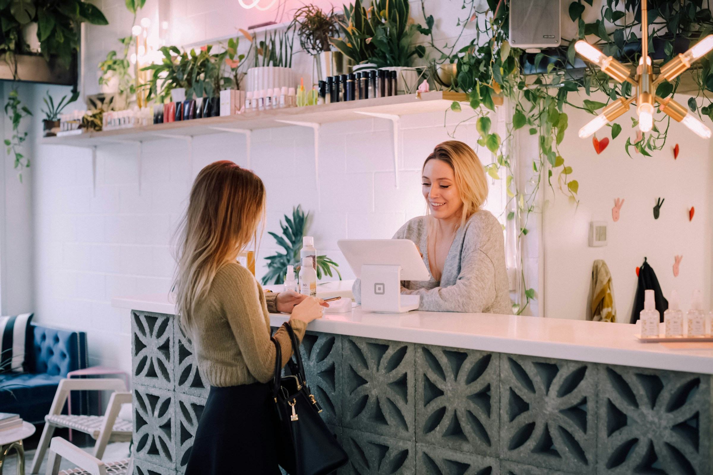 Une commerçante derrière le comptoir de sa boutique